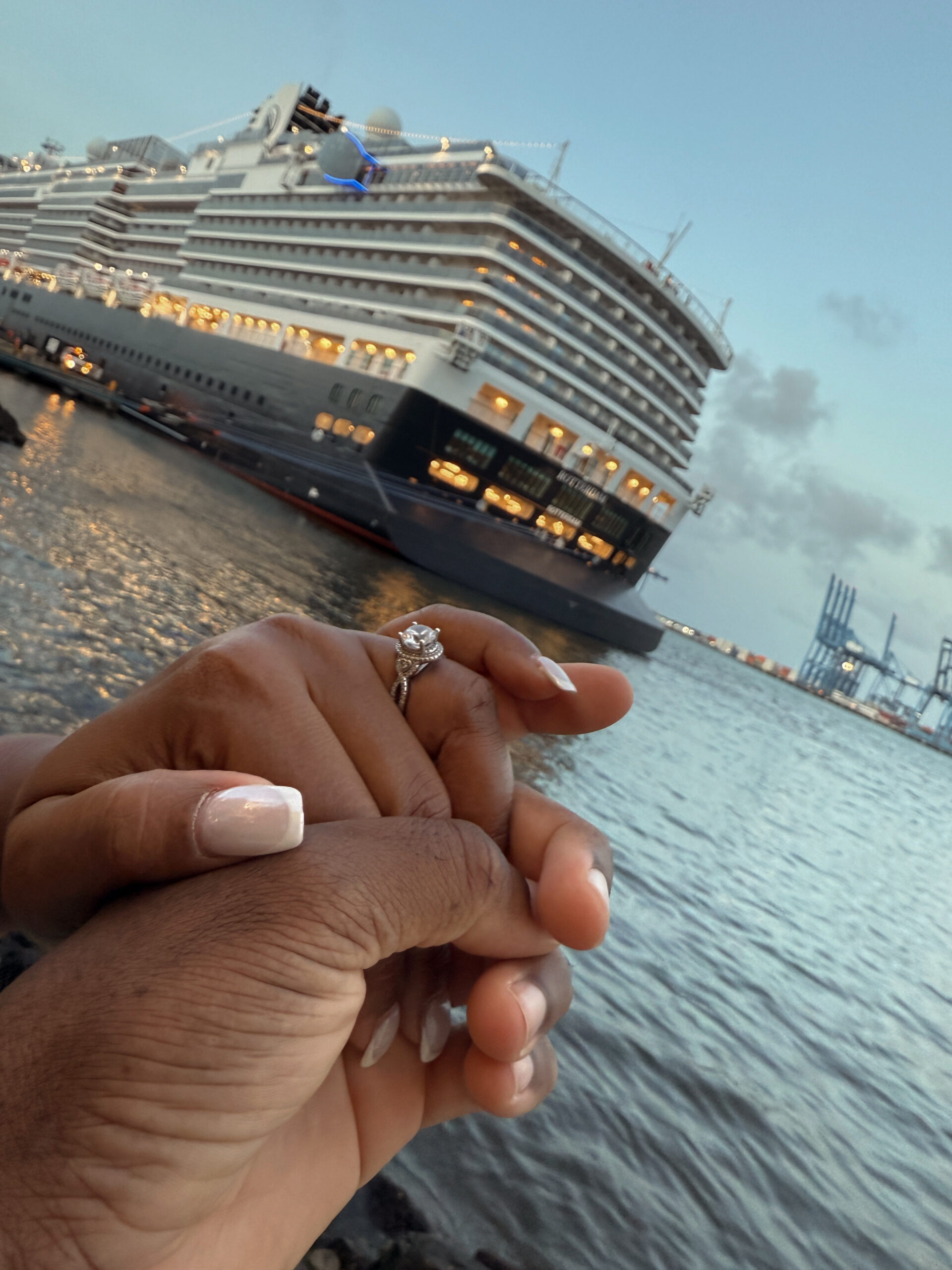 Couple holding hands in front of Rotterdam cruise ship